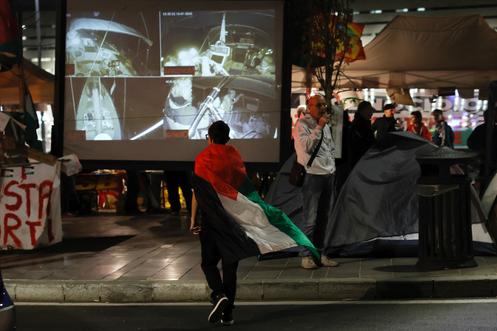 Un manifestant regarde le direct de la Global Sumud Flotilla, lors d’un rassemblement dans le centre de Rome après l’arraisonnement de la flottille pour Gaza par Israël, le 2 octobre 2025.