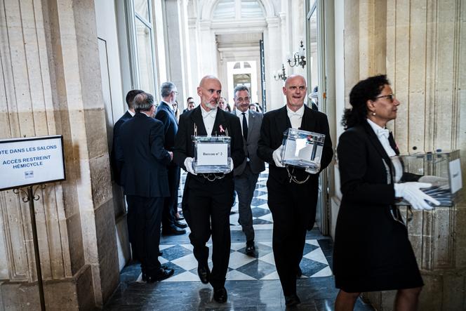 Des huissiers transportent les boîtes qui contiennent les votes des députés, à l’Assemblée nationale, à Paris, le 1er octobre 2025.