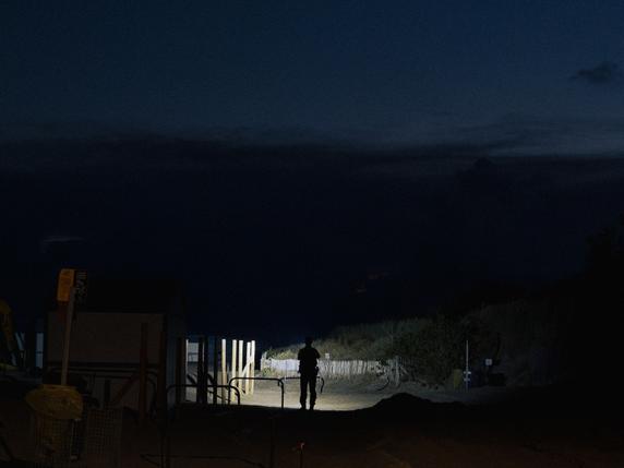 Un policier surveille la plage pour empêcher d’éventuelles embarcations de migrants, sur la plage de Petit-Fort-Philippe, à Gravelines (Nord), le 30 septembre 2025. 