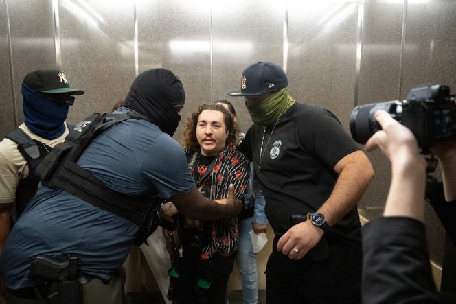 Des agents de l’ICE sortent d’un ascenseur Dean Moses, photographe du journal « AM New York », alors qu’ils détenaient un migrant. Dans un bâtiment où se trouvent des bureaux de l’immigration, à New York, le 30 septembre 2025.
