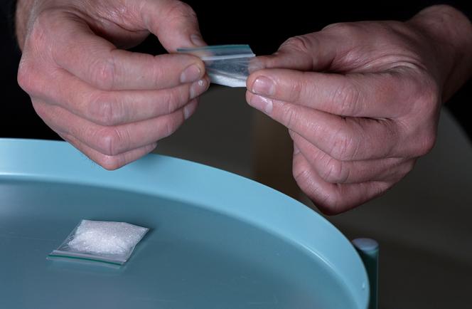 Un dealeur tenant un sachet de kétamine, à Londres, en juin 2025.