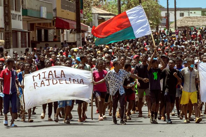 Des manifestants brandissent un drapeau malgache et une banderole cherchant à forcer le président Andry Rajoelina à démissionner, à Antsiranana (nord de Madagascar), le 1er octobre 2025.