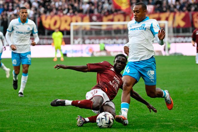 L’attaquant de Marseille Igor Paixao (maillot blanc) taclé par le défenseur messin Koffi Kouao, au Stade Saint-Symphorien de Metz, le 4 octobre 2025.