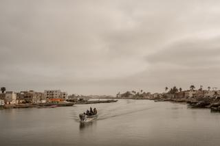 Des hommes reviennent de la pêche, sur le fleuve Sénégal, entre la langue de Barbarie et l'île de Saint-Louis, le 25 juin 2025.