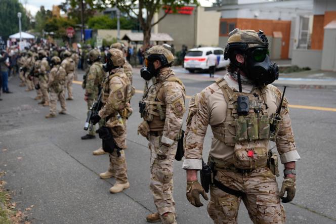 Des agents des forces de l’ordre bloquent la route pour empêcher un véhicule d’entrer dans un centre de l’agence américaine de contrôle de l’immigration et des douanes, le 4 octobre 2025, à Portland, dans l’Oregon.