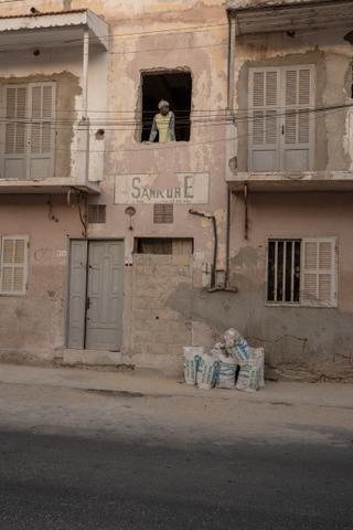 Un ouvrier à la fenêtre d'un édifice patrimonial en rénovation, sur l’île de Saint-Louis, le 27 juin 2025.
