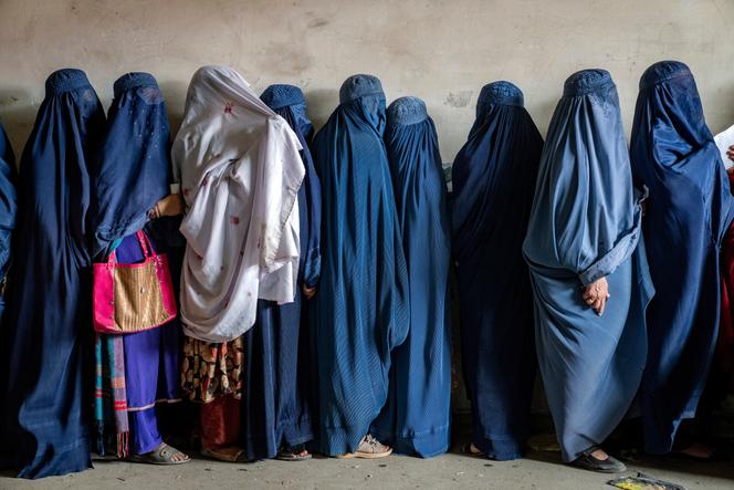 As mulheres afegãs esperam para receber rações alimentares distribuídas por um grupo de ajuda humanitária, em Cabul, Afeganistão, 23 de maio de 2023.