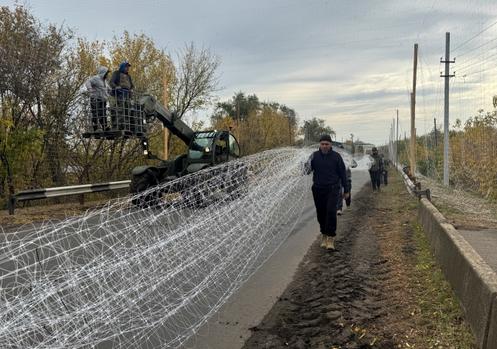 Des militaires ukrainiens installent des filets antidrones sur une route, près de la ville de Dobropillia, située en première ligne, dans l’oblast de Donetsk, en Ukraine, le 8 octobre 2025.