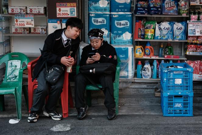 Des étudiants devant un magasin à Séoul, le 21 mars 2025.