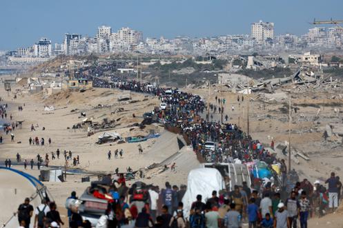 Des personnes qui avaient été déplacées vers le sud de la bande de Gaza empruntent une route pour retourner dans le Nord après l’entrée en vigueur du cessez-le-feu, dans le centre de la bande de Gaza, vendredi 10 octobre 2025.