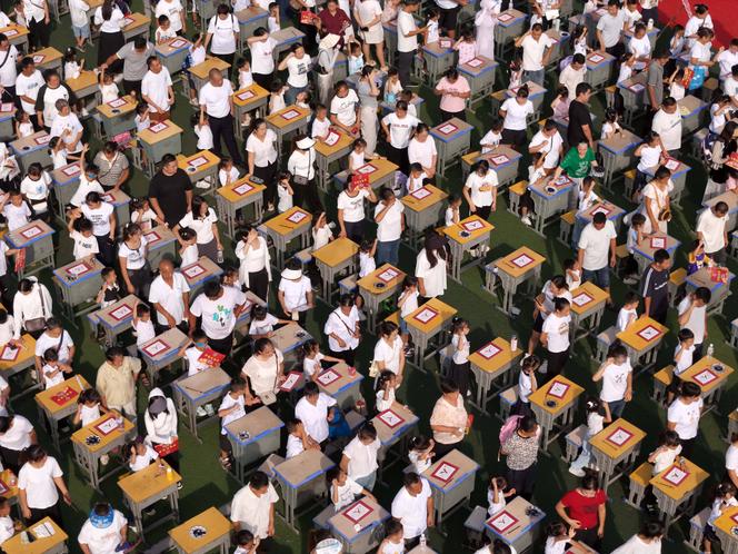 Des élèves accompagnés de leurs parents lors de la cérémonie d’écriture d’une école primaire du comté de Cengong, dans le district administratif de la province du Guizhou, en Chine, le 4 septembre 2025.