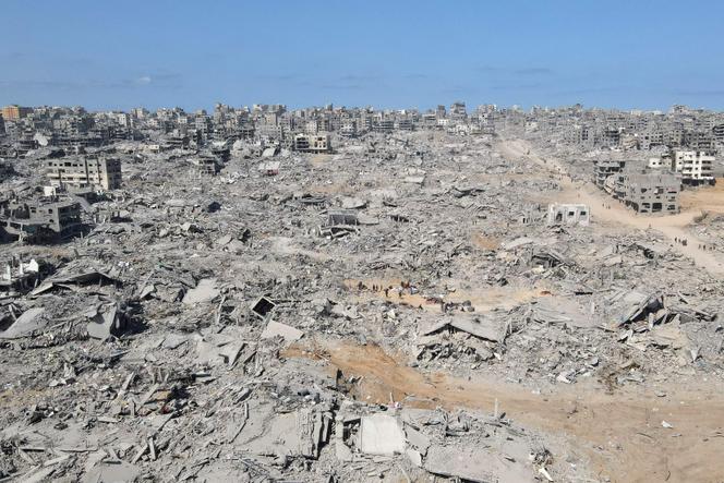 Des gens marchent au milieu des destructions, dans le nord de la bande de Gaza, le 11 octobre 2025.