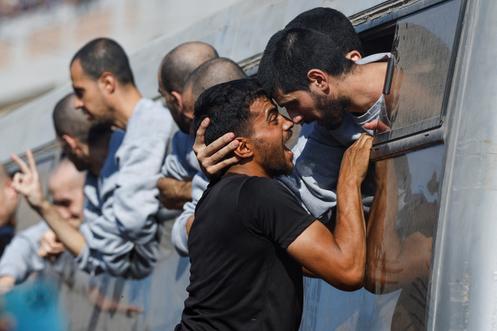 Un homme salue un prisonnier palestinien libéré par Israël à Khan Younès, le 13 octobre 2025.