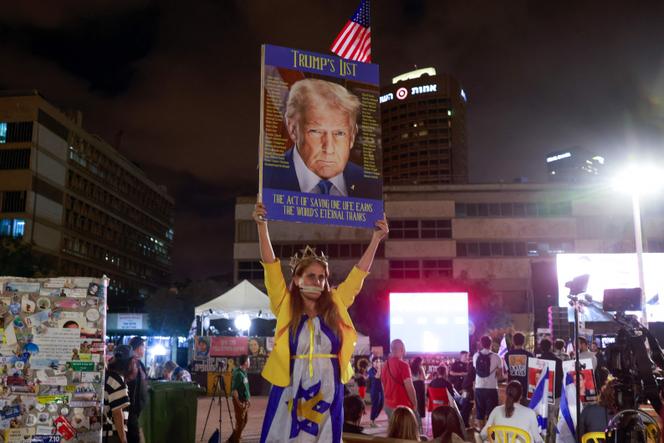 Une femme brandit une affiche de Donald Trump sur la « place des Otages », à Tel-Aviv, tôt le 13 octobre 2025.