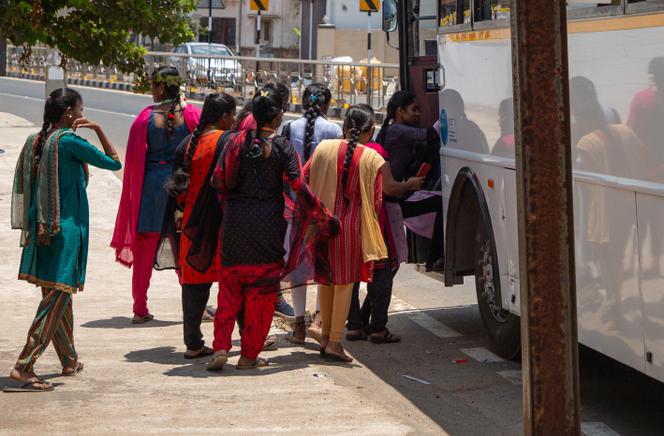 Des ouvrières montent dans le bus les emmenant à l’usine Foxconn, près du village de Molachur (Tamil Nadu), en Inde, le 1ᵉʳ avril 2024.