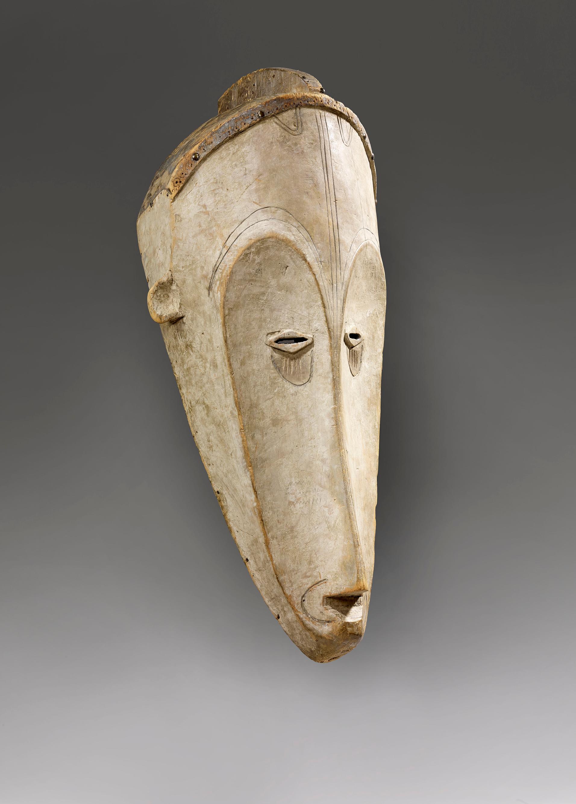 Ngil yüz maskesi, Fang halkı, Gabon, 19. yüzyıl, 20. yüzyıl başı (ahşap, kaolin ve bakır alaşımlı çiviler, 69 cm x 28 cm x 25 cm).