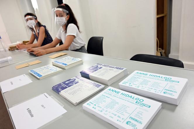 Des assesseurs équipés de masques et de gants, à l’occasion du second tour des élections municipales à Paris, le 26 juin 2020.