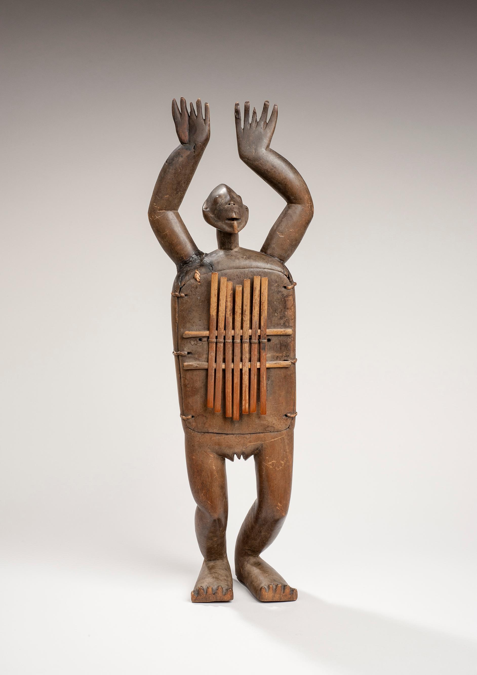 Antropomorfik Zande lamelfonu, Demokratik Kongo Cumhuriyeti (DRC), 19. yüzyıl, 20. yüzyıl başı (ahşap ve bambu, 61 cm x 15 cm).