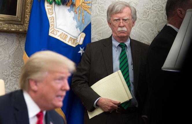 John Bolton, alors conseiller à la sécurité nationale, se tient en retrait de Donald Trump, dans le bureau Ovale de la Maison Blanche, à Washington, le 17 mai 2018.