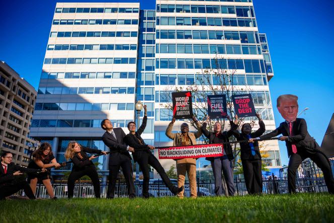 Militants pour le climat devant le siège du Fonds monétaire international, à Washington, le 16 octobre 2025.