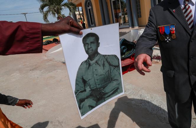 Une personne montre une photo d’un proche tué lors du massacre de Thiaroye, lors de la commémoration du 80e anniversaire de la tragédie, à Thiaroye, au Sénégal, le 1er décembre 2024.
