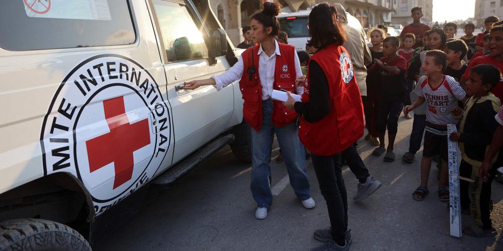Des Palestiniens et des membres du Comité international de la Croix-Rouge (CICR) se rassemblent sur un site où des excavatrices sont utilisées pour creuser à la recherche de corps, à Khan Younès, dans le sud de la bande de Gaza, le 17 octobre 2025. - OMAR AL-QATTAA / AFP