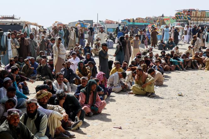 Des Afghans attendent alors qu’ils tentent de retourner dans leur pays, après la fermeture par le Pakistan des postes-frontières commerciaux avec l’Afghanistan à la suite d’échanges de tirs entre les deux pays, au poste-frontière de Chaman, au Pakistan, le 18 octobre 2025.