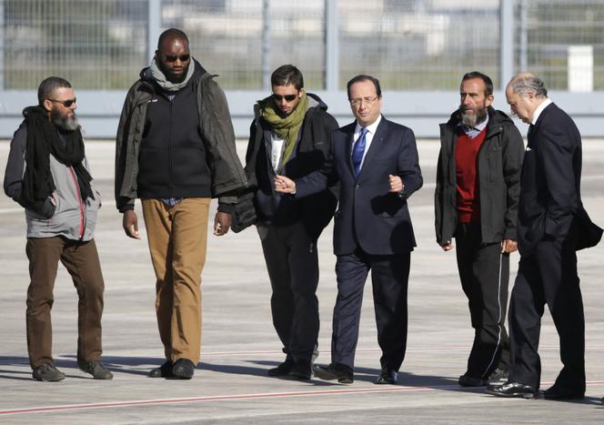 Les quatre derniers otages, Marc Féret, Thierry Dol, Pierre Legrand et Daniel Larribe, accompagnés de François Hollande et de Laurent Fabius, le 30 octobre 2013, à l’aéroport de Villacoublay (Yvelines).