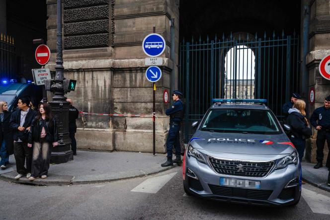 Des policiers français se tiennent devant le musée du Louvre après un cambriolage, à Paris, le 19 octobre 2025.