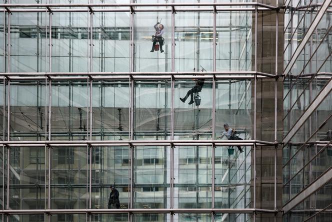 Des nettoyeurs de vitres, sur un immeuble du quartier d’affaires de la Défense (Hauts-de-Seine), le 9 octobre 2025.