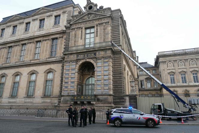 Des policiers se tiennent à côté d’un monte-meubles utilisé par des cambrioleurs pour pénétrer dans le Musée du Louvre, sur le quai François-Mitterrand, à Paris, le 19 octobre 2025.