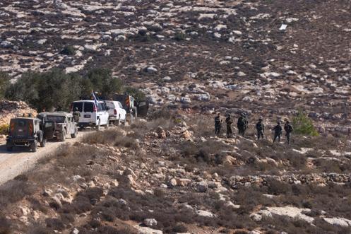 Des soldats israéliens prennent position pendant que des Palestiniens récoltent des olives dans le village de Turmus Ayya, en Cisjordanie, à la périphérie de Ramallah, le 20 octobre 2025.