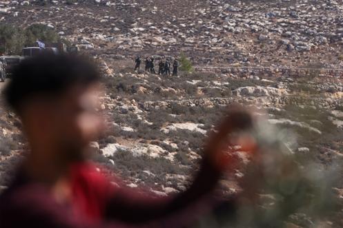 Des soldats israéliens prennent position pendant que des Palestiniens récoltent des olives dans le village de Turmus Ayya, en Cisjordanie, à la périphérie de Ramallah, le 20 octobre 2025.