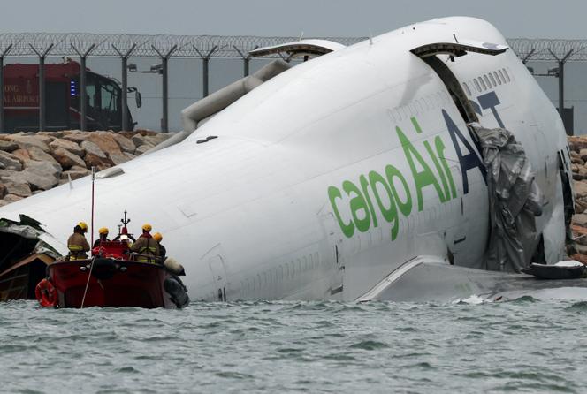 Les secours interviennent près d’un avion-cargo partiellement immergé dans la mer après être sorti de la piste lors de son atterrissage à l’aéroport international de Hong Kong, le 20 octobre 2025.