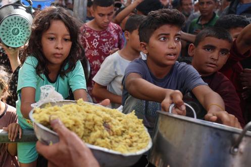 Distribution de nourriture dans le camp de déplacés de Nuseirat, dans le centre de la bande de Gaza, le 21 octobre 2025.