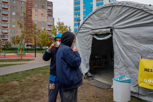 Des enfants boivent du thé devant un point d’invincibilité, lors d’une coupure d’électricité due à une attaque de drone russe, à Tchernihiv, en Ukraine, le 21 octobre 2025.