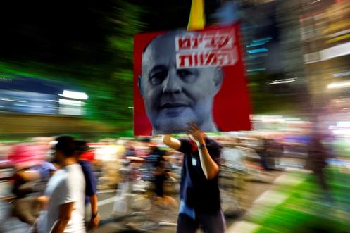 Un manifestant brandit le portrait de l’ancien conseiller à la sécurité nationale israélien, Tzachi Hanegbi, lors d’une manifestation pour le retour des otages du 7-Octobre, à Tel-Aviv (Israël), le 10 octobre 2024.