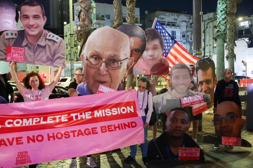 Des manifestants brandissent des portraits d’otages morts toujours détenus par le Hamas dans la bande de Gaza, à Tel-Aviv, le 21 octobre 2025.