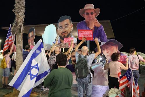 Des manifestants brandissent des portraits d’otages morts toujours détenus par le Hamas dans la bande de Gaza, alors qu’ils se rassemblent devant l’ambassade des Etats-Unis à Tel-Aviv, le 21 octobre 2025. Ils appellent le président américain, Donald Trump, à ne laisser aucun otage entre les mains du Hamas, alors que le vice-président américain J. D. Vance continue sa visite d'Israël.