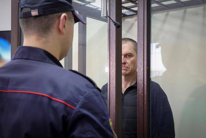 Journalist Andrzej Poczobut stands in a defendants' cage during a court session in Grodno, Belarus, on January 16, 2023.