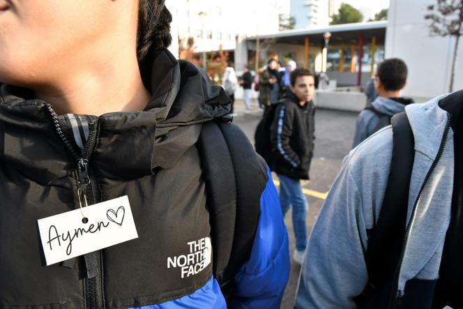 Un jeune porte une étiquette en hommage à Aymen, au collège Les Escholiers de la Mosson, où il était scolarisé, à Montpellier, le 16 décembre 2022.