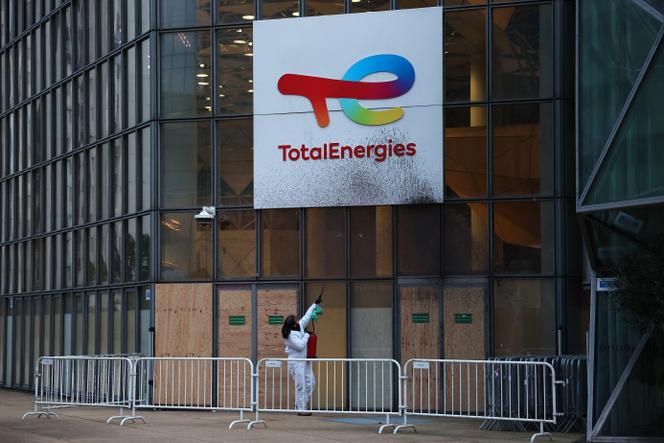 Un militant de Greenpeace peint à la bombe le logo de TotalEnergies lors d’une manifestation contre les pollueurs devant le siège de la multinationale, dans le quartier d’affaires de La Défense (Hauts-de-Seine), le 18 novembre 2024.