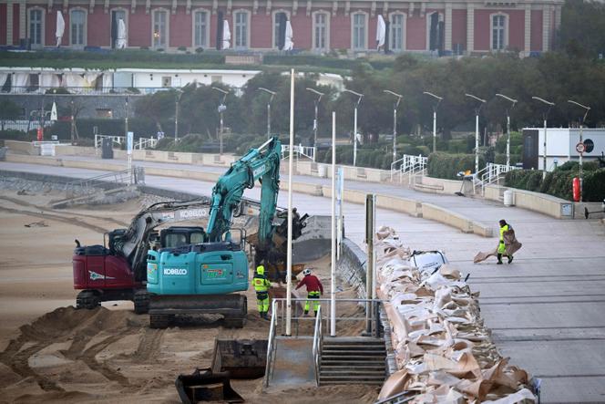 Des pelles mécaniques déposent des sacs de sable pour protéger la promenade de la Grande Plage, à Biarritz, dans les Pyrénées-Atlantiques, le 23 octobre 2025.