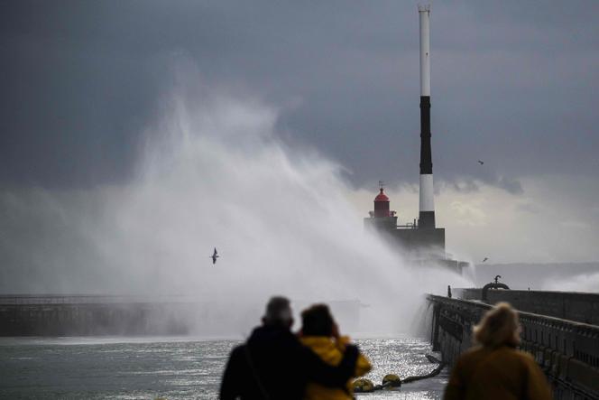 Des piétons observent les vagues se briser sur le phare de la digue Nord, au Havre, en Seine-Maritime, le 23 octobre 2025.