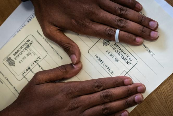 Mohamed carefully keeps his documents related to the readmission agreements between England and France, in Paris, on October 16, 2025.