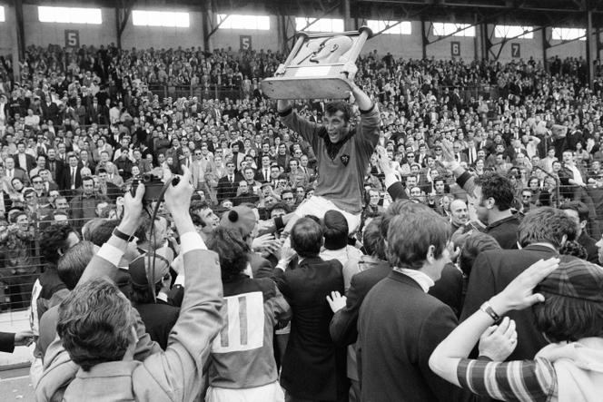 RC Toulon rugby player André Herrero holds the trophy and celebrates with supporters their victory over SU Agen at the Challenge Yves du Manoir, on May 24, 1970 in Colombes.  