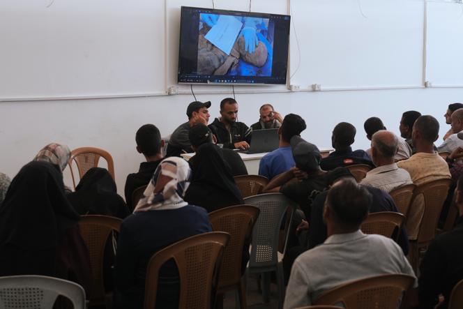 Des Palestiniens regardent un écran montrant l’examen des corps de prisonniers restitués par Israël, à l’hôpital Nasser de Khan Younès, le 21 octobre 2025.