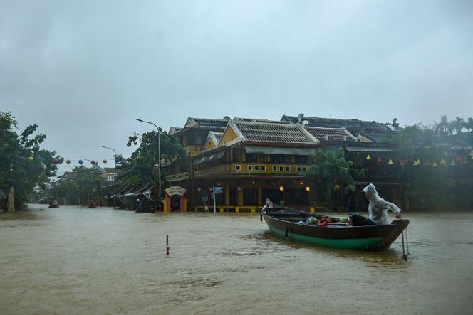 Des personnes naviguent sur une route inondée à bord d’un bateau après de fortes pluies à Hoi An, dans le centre du Vietnam, le 27 octobre 2025.