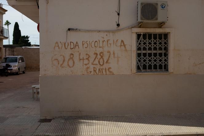 Un message écrit avec de la boue au début des inondations d’octobre 2024 à Valence, toujours visible un an plus tard. On y lit : « Aide psychologique gratuite », avec un numéro de téléphone à contacter. A Algemesi, dans la région de Valence (Espagne), le 22 octobre 2025.