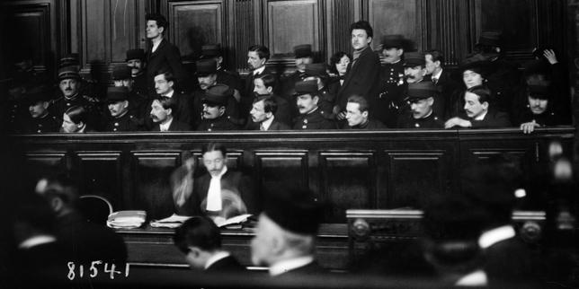 Procès de la « bande à Bonnot », à Paris, le 7 février 1913. Victor Serge est au premier rang (le quatrième à partir de la droite) et Rirette Maîtrejean probablement au dernier rang (au-dessus de Victor Serge).
